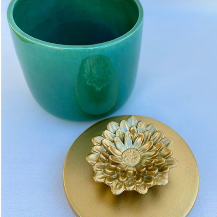 Pote verde com tampa de flor dourada